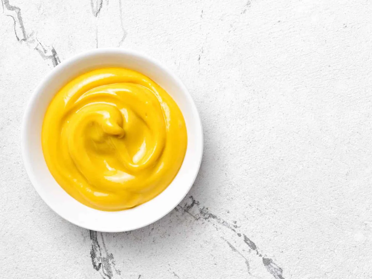 Yellow mustard in a small white bowl