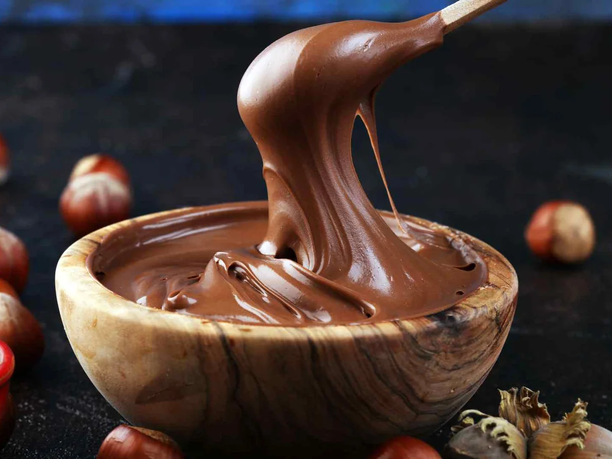 Chocolate hazelnut spread pouring into a small bowl