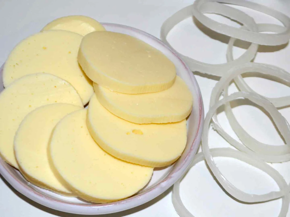 Round provolone slices arranged beside metal dividers