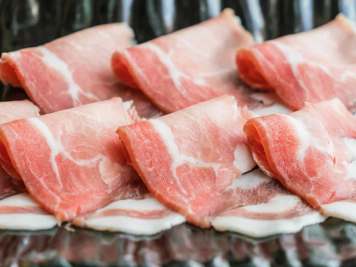 Thick raw pork belly pieces arranged on a tray