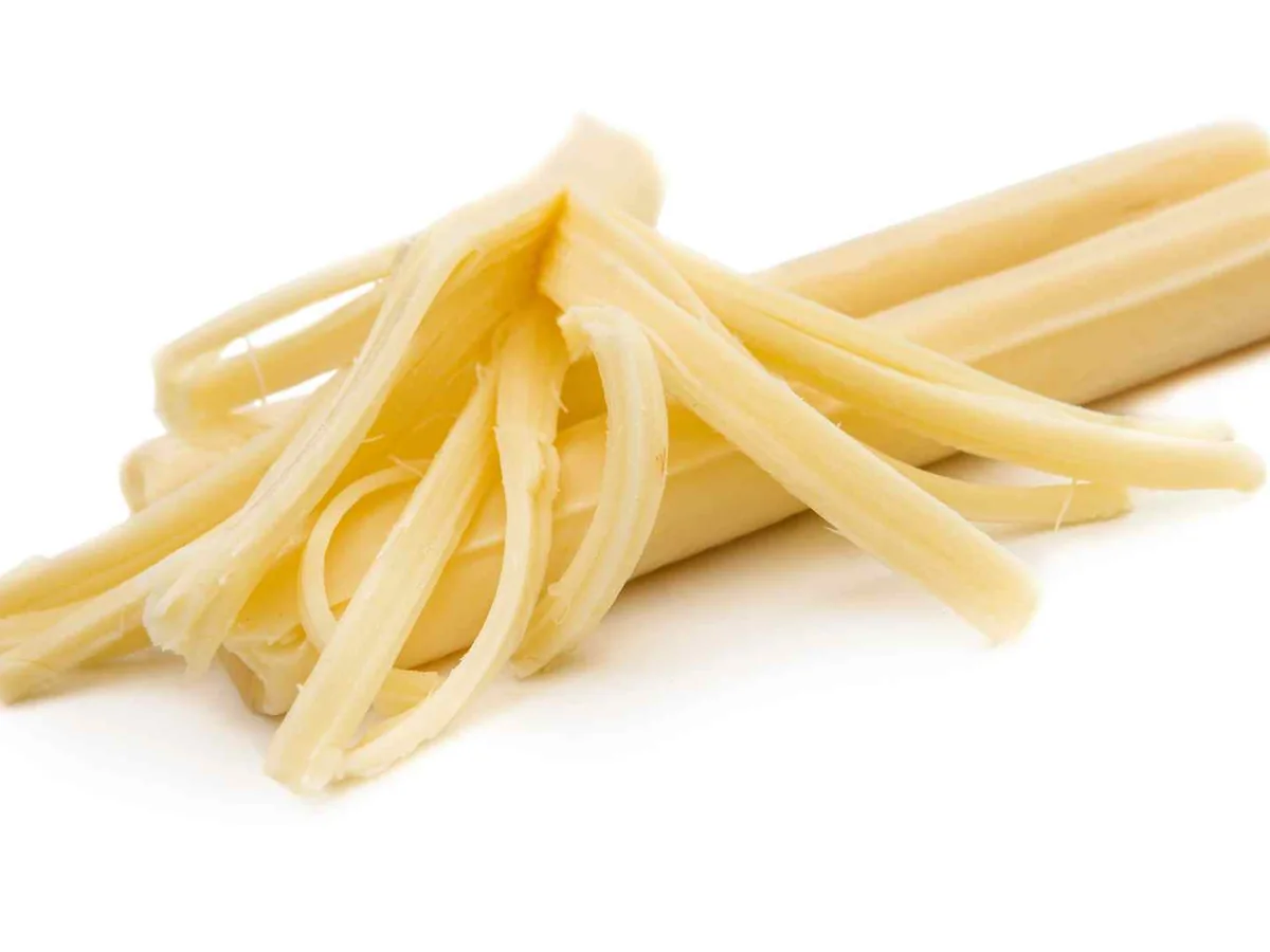 A small pile of pulled string cheese strands on white