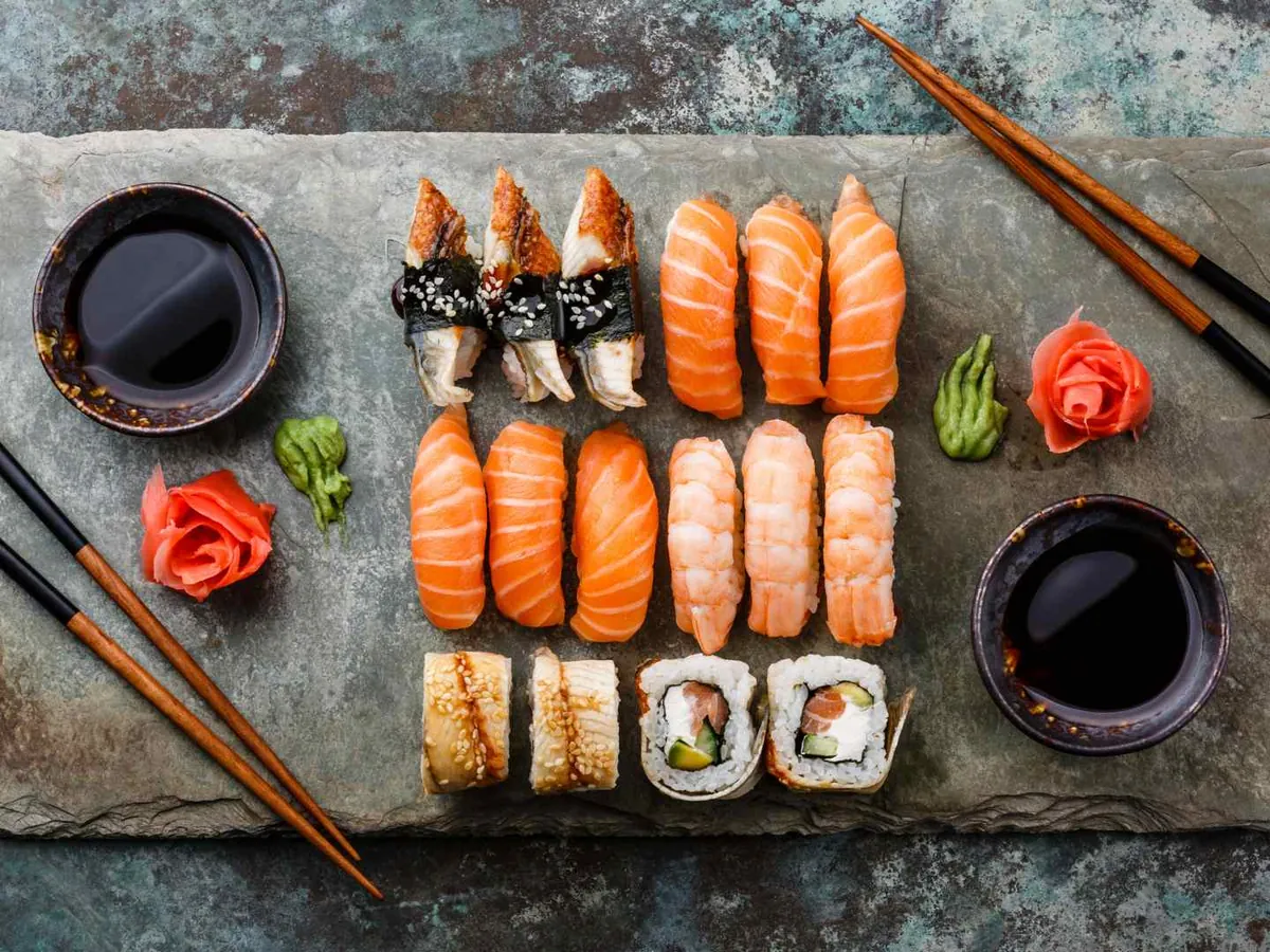Rows of sushi and nigiri with chopsticks and soy sauce