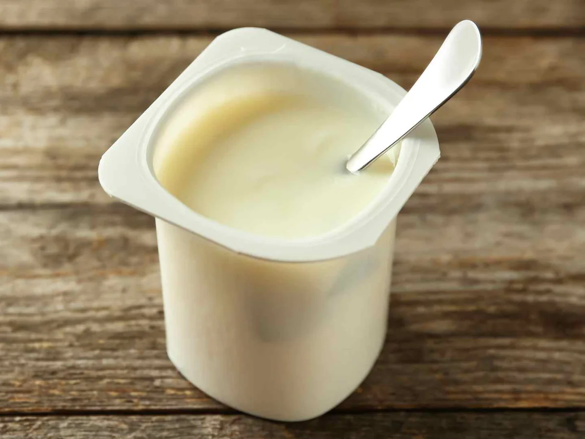 A plain single-serve yogurt cup with a white spoon