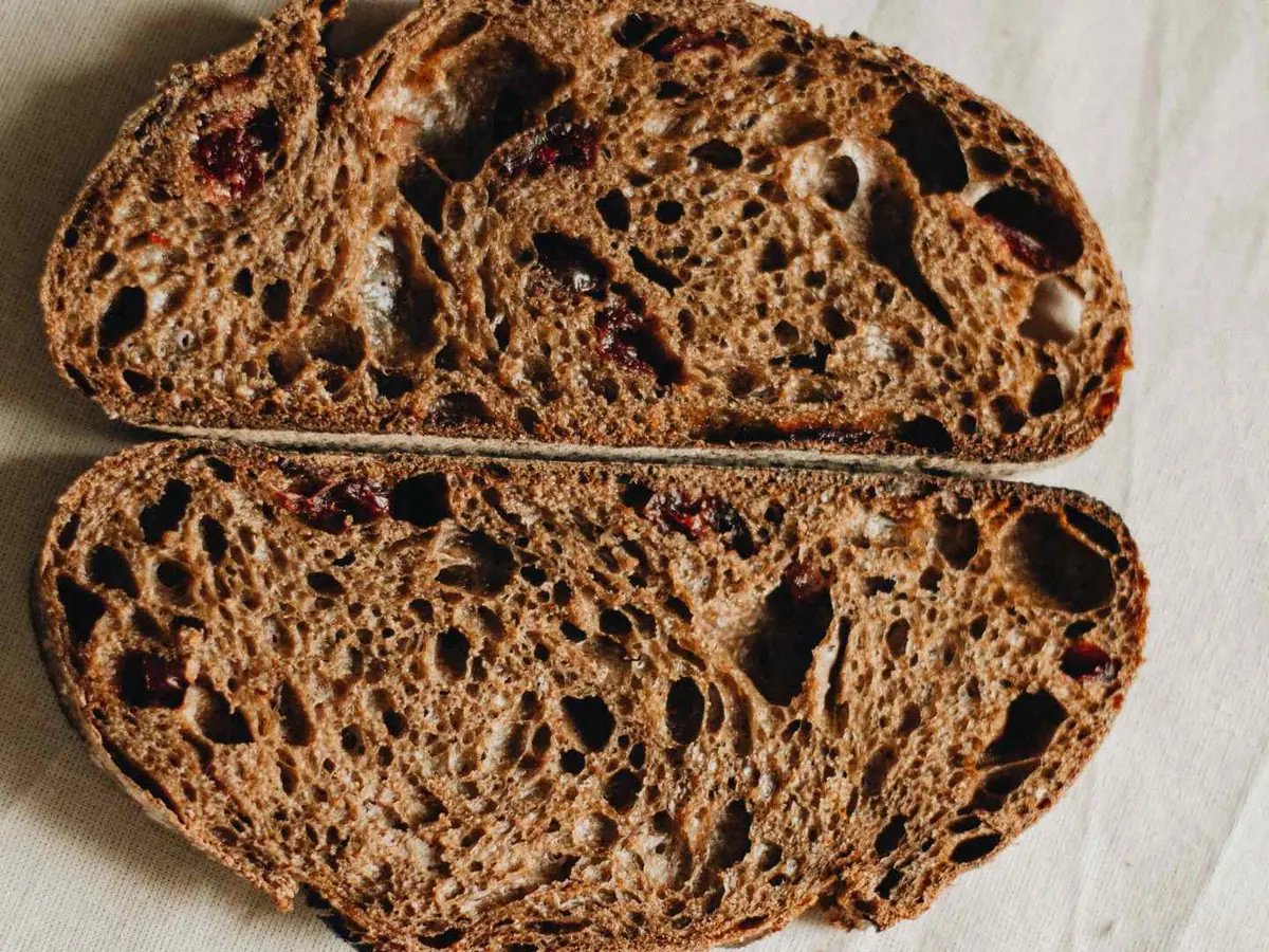 Two cut halves of a dark seeded bread loaf