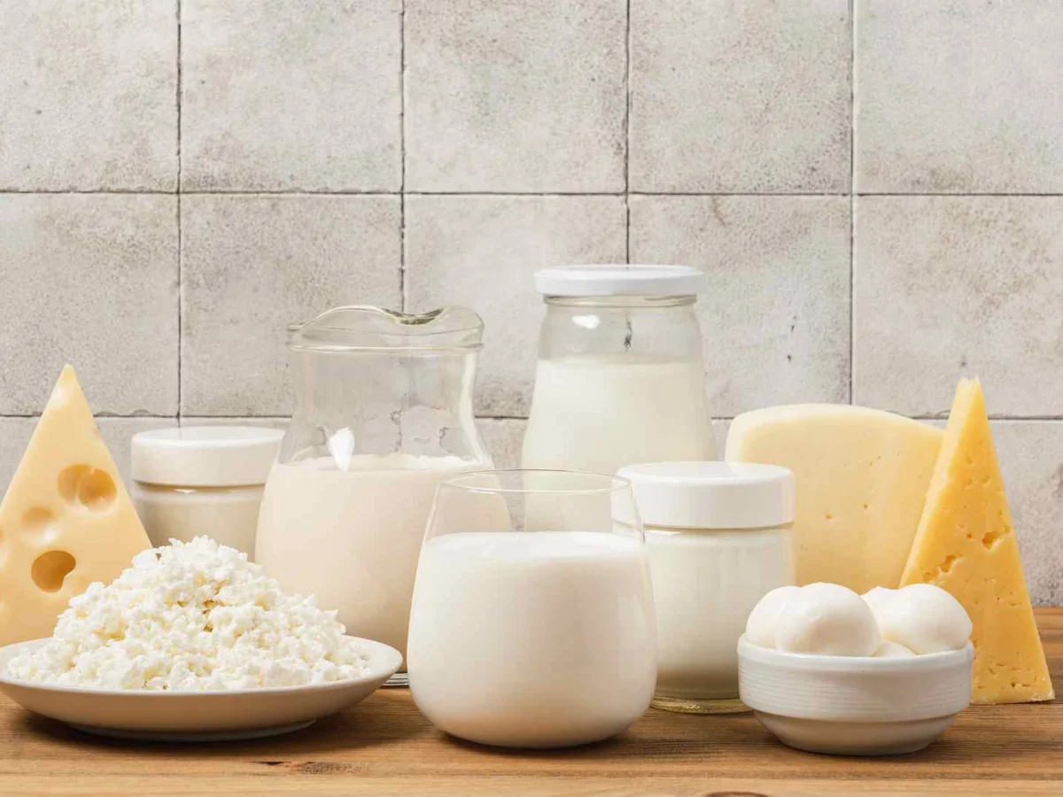 Milk, cheese, and cottage cheese arranged on a pale table