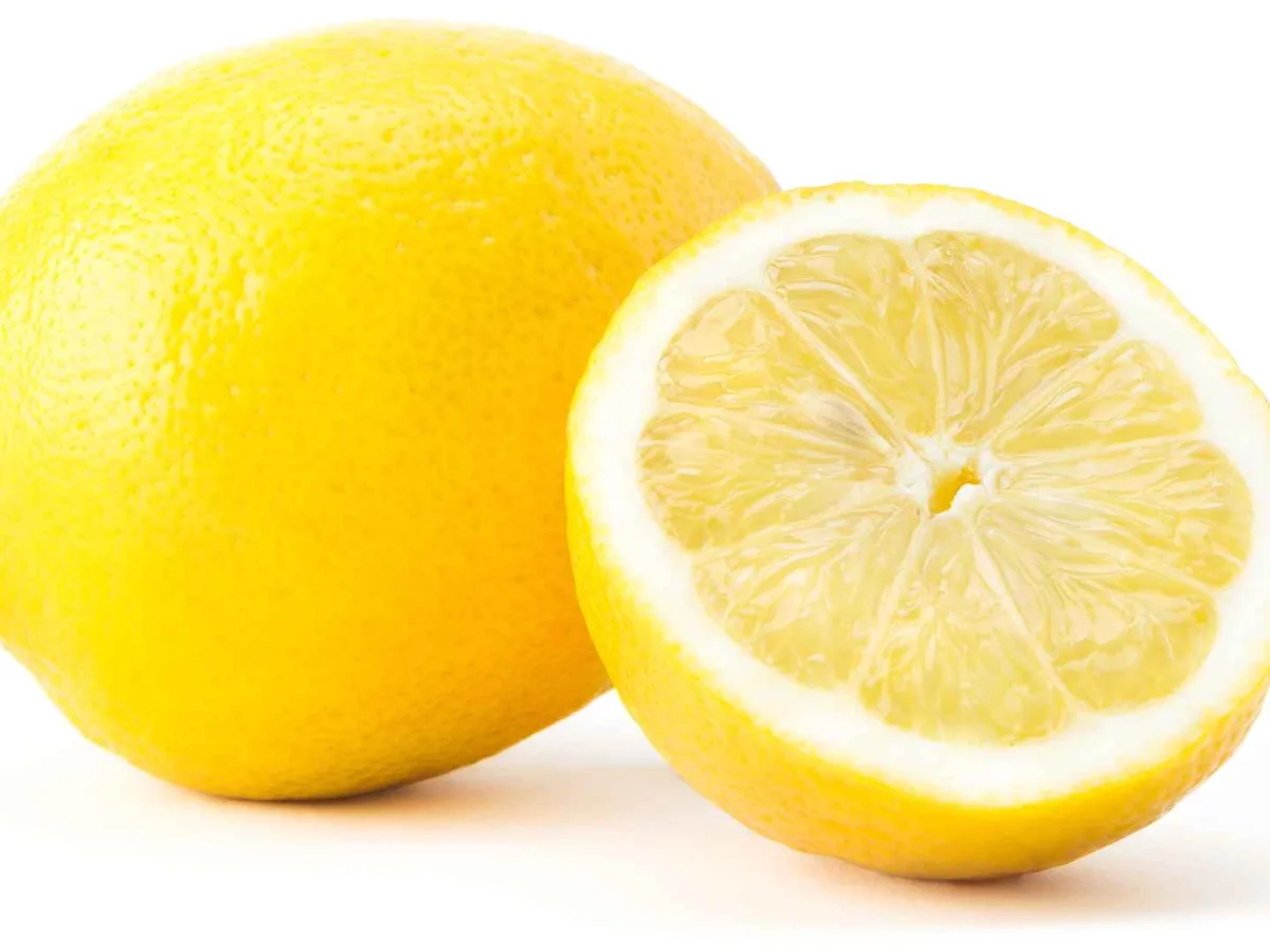 One whole lemon and one lemon half on white