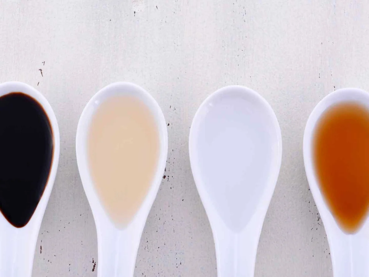 Four white spoons holding vinegars in different colors
